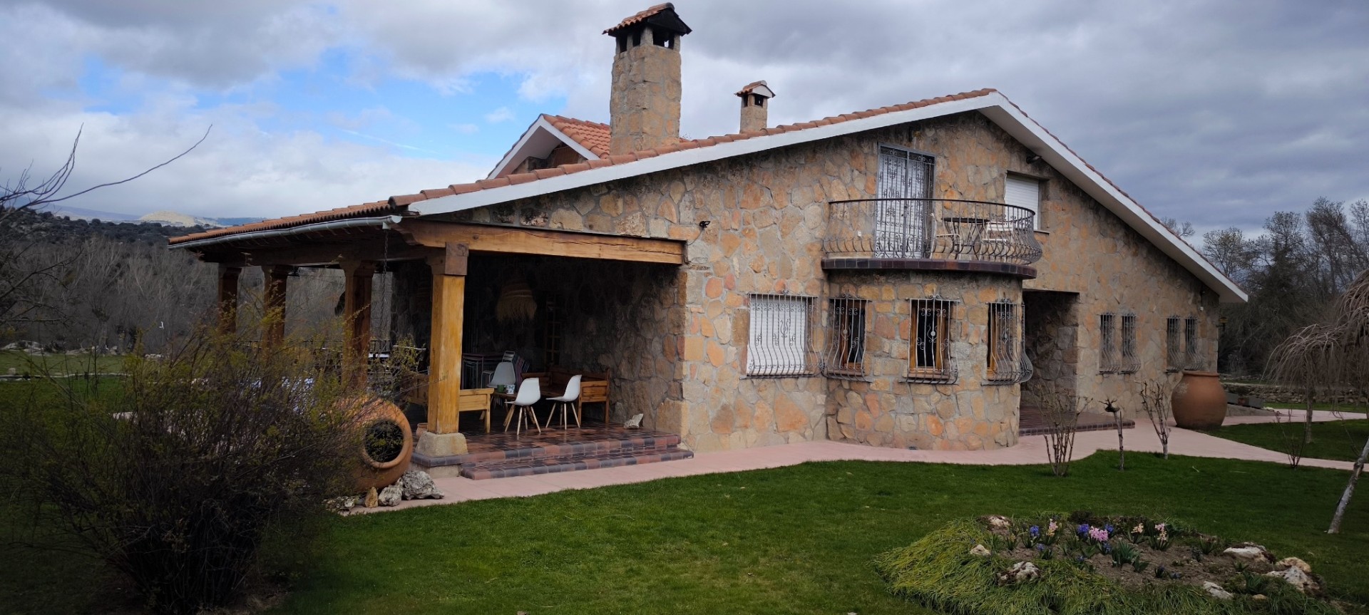 Vivienda de piedra con chimenea y balcón realizada por Obras Jesús Pérez