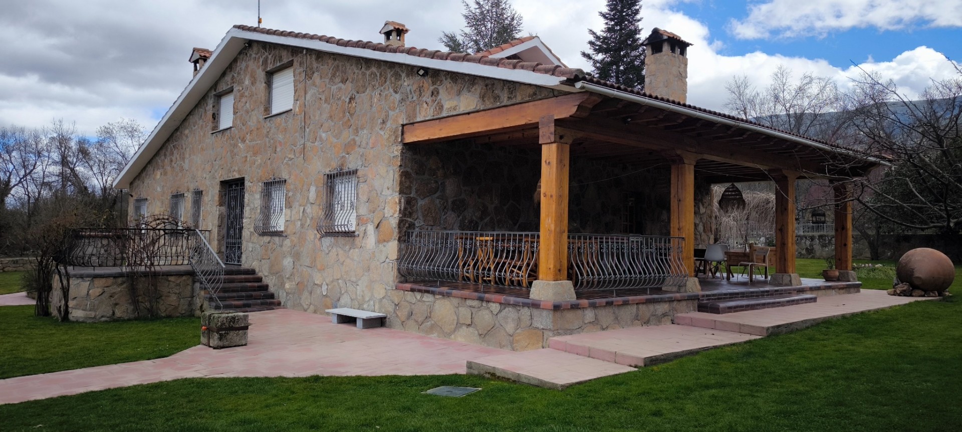 Chalet de piedra con porche y barandilla forjada realizado por Obras Jesús Pérez