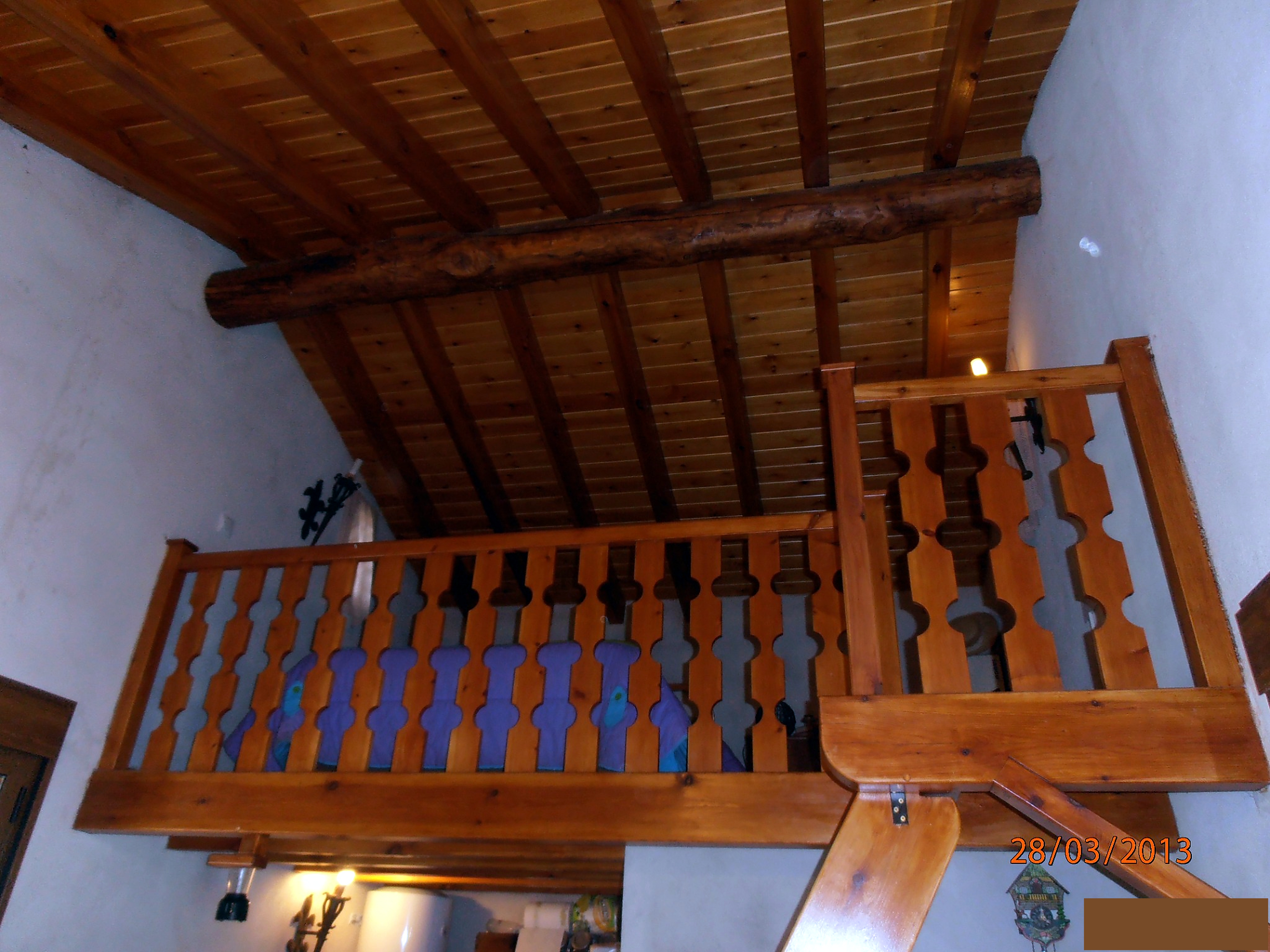 Interior con vigas y barandilla de madera realizado por Obras Jesús Pérez