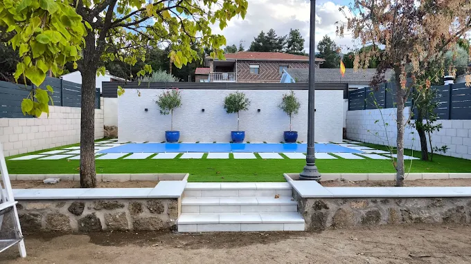 Piscina con jardín, olivos y muro de piedra realizada por Obras Jesús Pérez