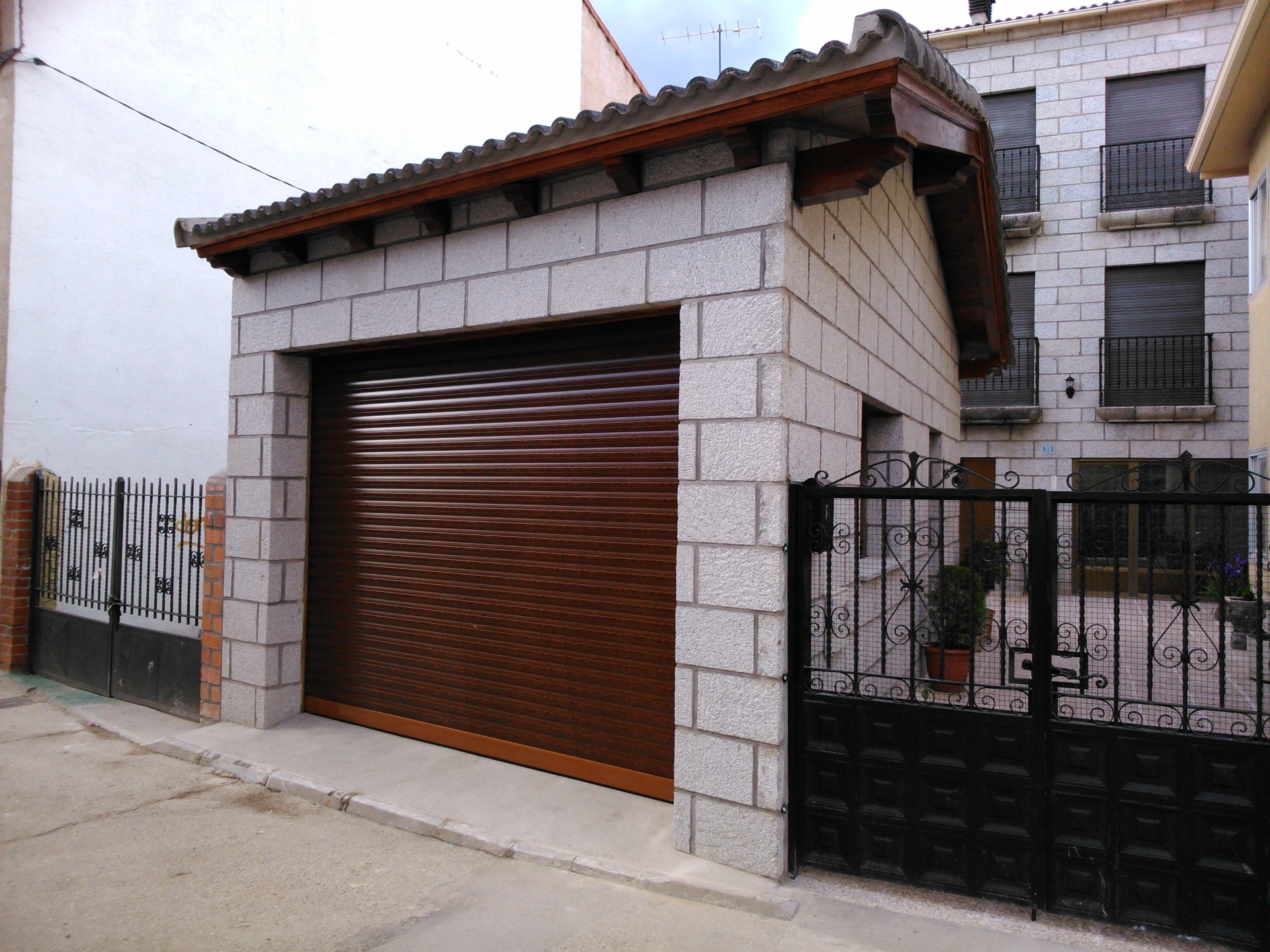Garaje de bloque de piedra con puerta de madera realizado por Obras Jesús Pérez