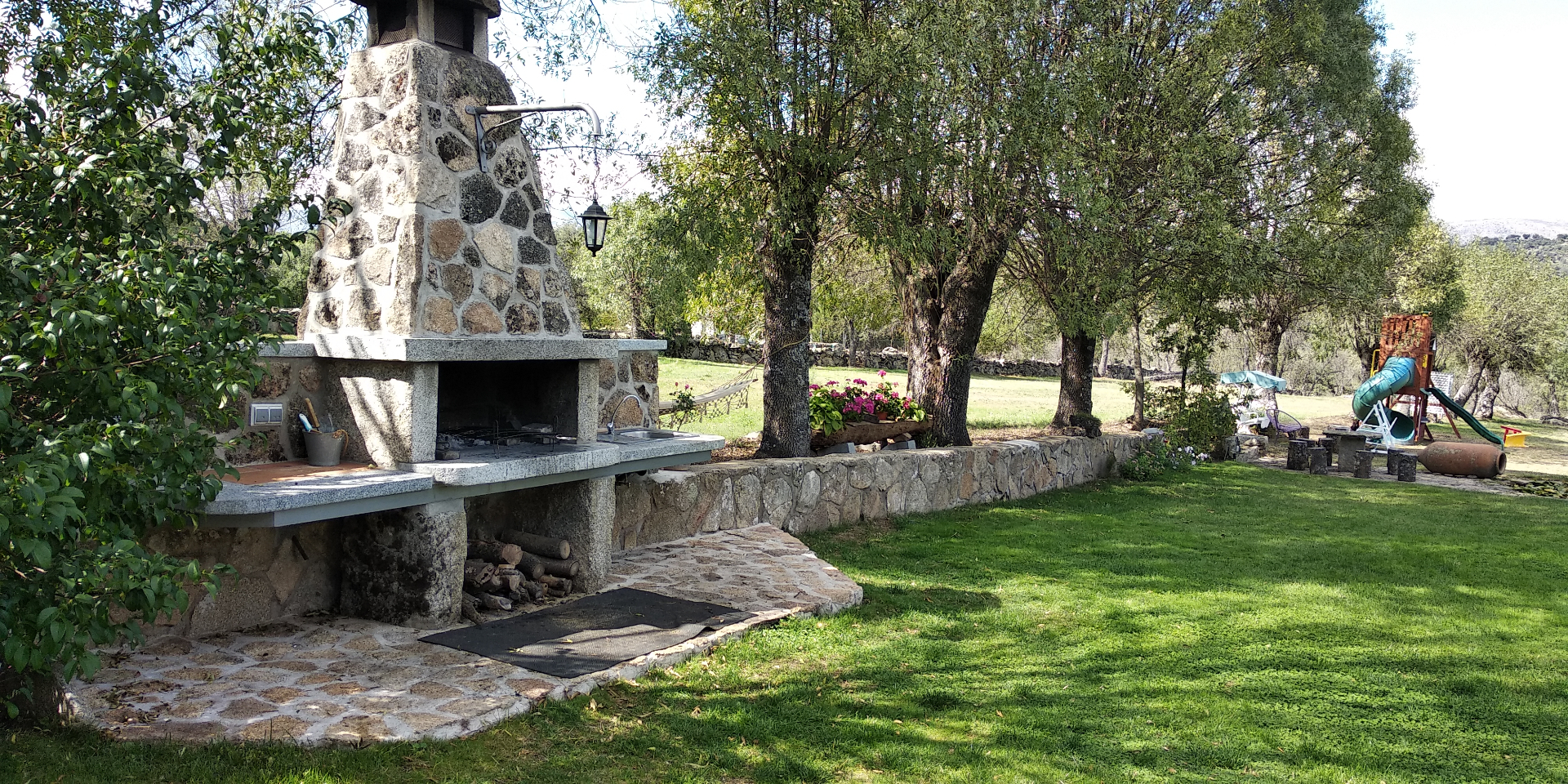 Barbacoa de piedra en jardín realizada por Obras Jesús Pérez