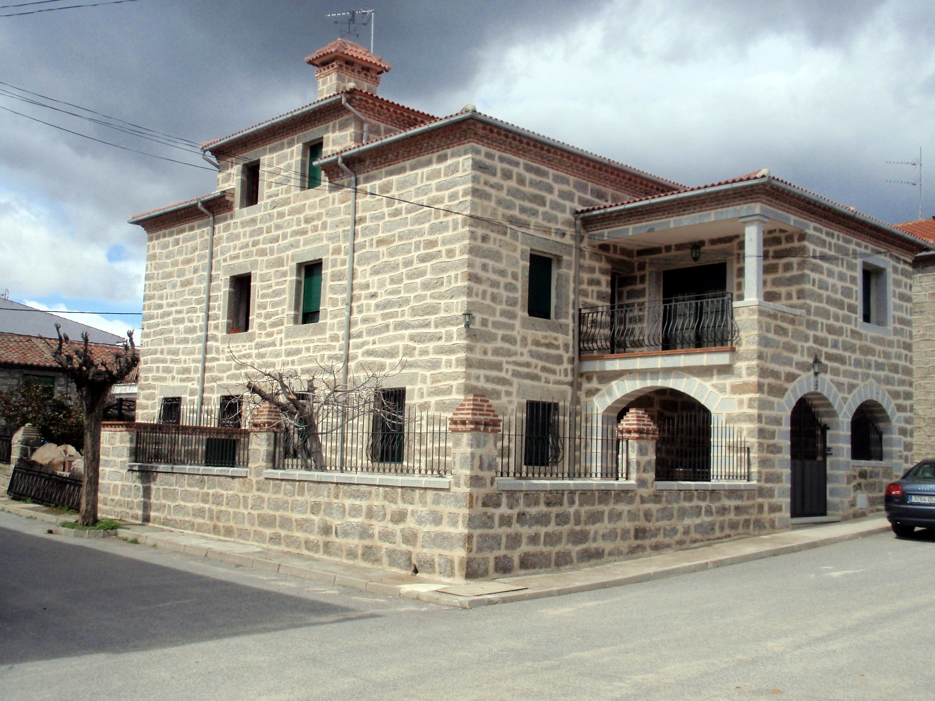 Vivienda de piedra con balcón y arcos realizada por Obras Jesús Pérez
